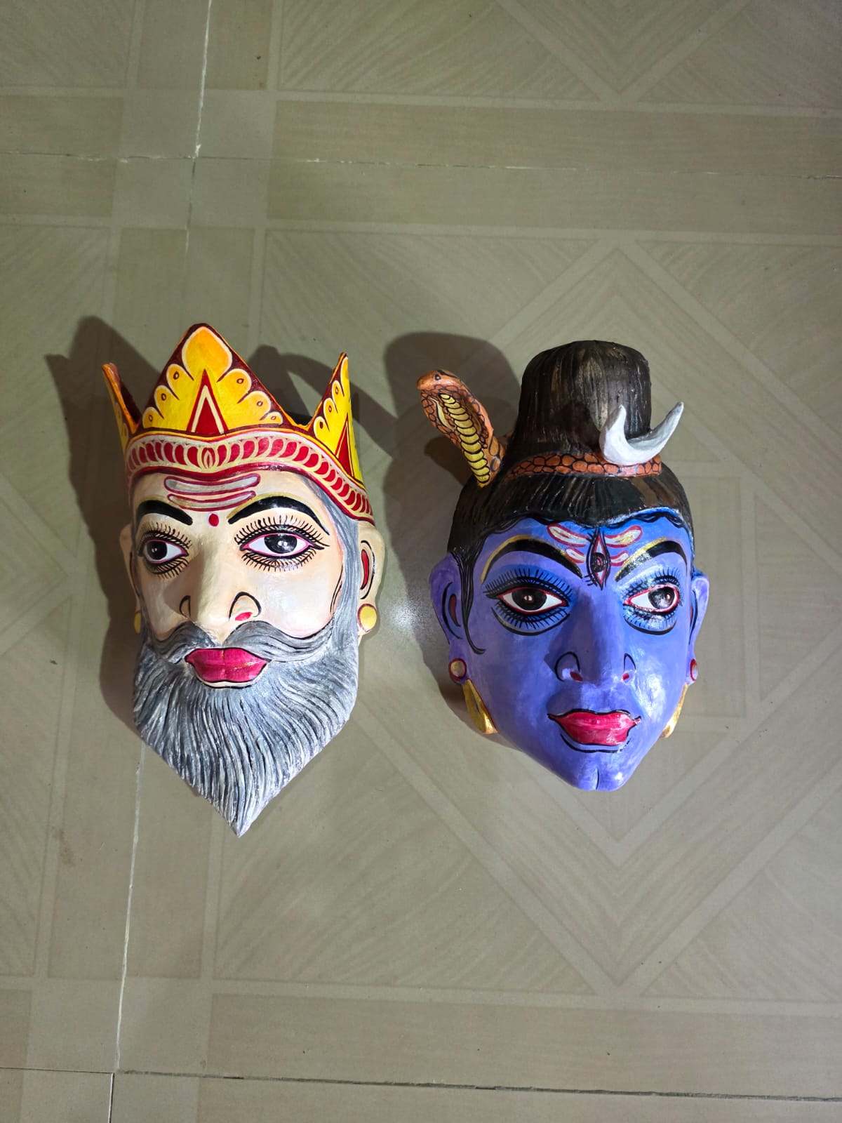 A royal king mask and a blue Shiva mask